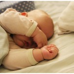 Baby boy sleeping with his arm over his eyes